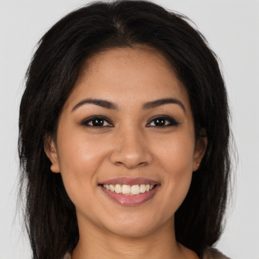 Joyful latino young-adult female with long  brown hair and brown eyes