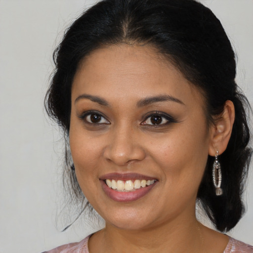 Joyful latino young-adult female with medium  brown hair and brown eyes