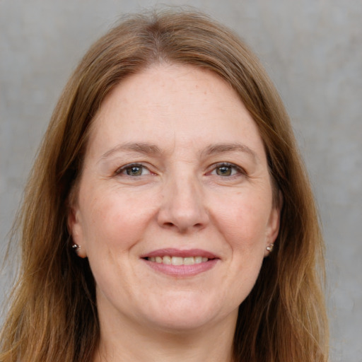 Joyful white adult female with long  brown hair and grey eyes