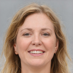 Joyful white adult female with long  brown hair and grey eyes