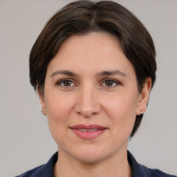 Joyful white adult female with medium  brown hair and brown eyes