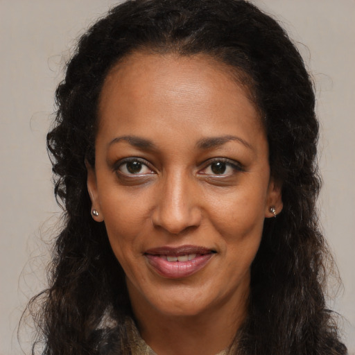 Joyful black young-adult female with long  brown hair and brown eyes