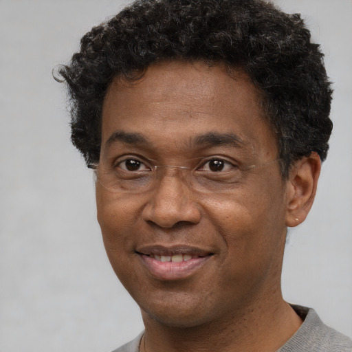 Joyful black adult male with short  brown hair and brown eyes