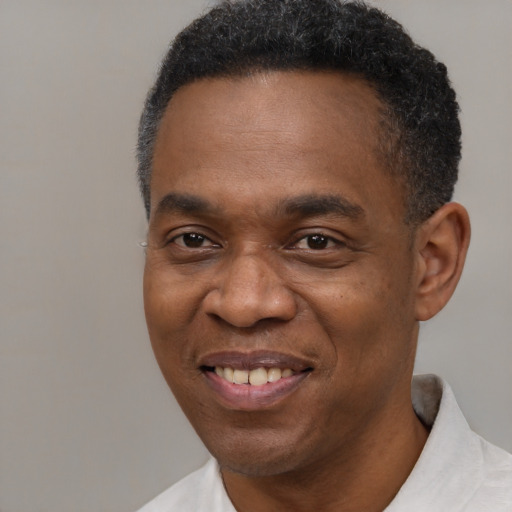Joyful black adult male with short  black hair and brown eyes