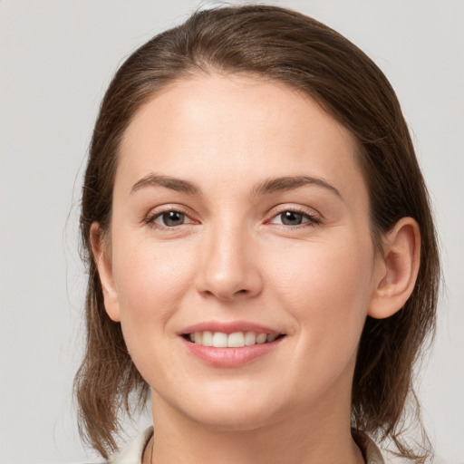 Joyful white young-adult female with medium  brown hair and grey eyes