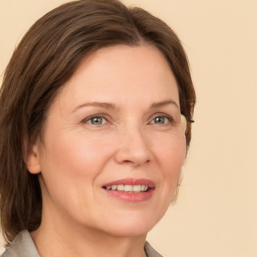 Joyful white adult female with medium  brown hair and grey eyes