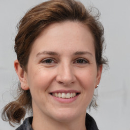 Joyful white adult female with medium  brown hair and grey eyes