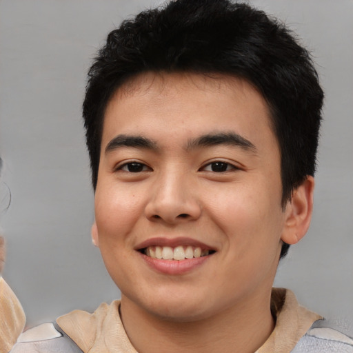 Joyful asian young-adult male with short  brown hair and brown eyes