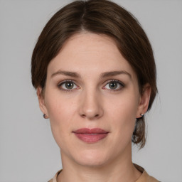 Joyful white young-adult female with medium  brown hair and grey eyes