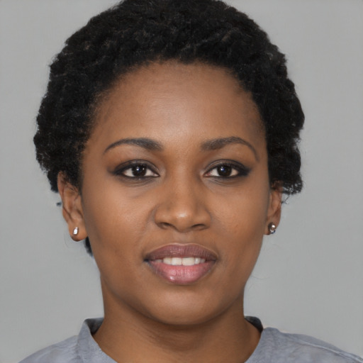 Joyful black young-adult female with short  black hair and brown eyes
