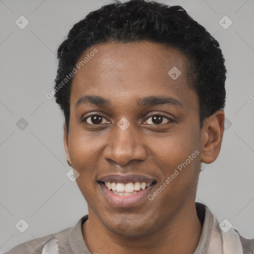 Joyful black young-adult male with short  black hair and brown eyes