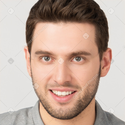 Joyful white young-adult male with short  brown hair and grey eyes