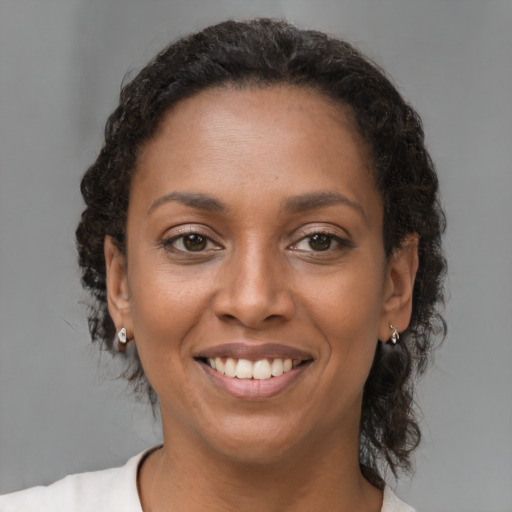 Joyful black young-adult female with medium  brown hair and brown eyes