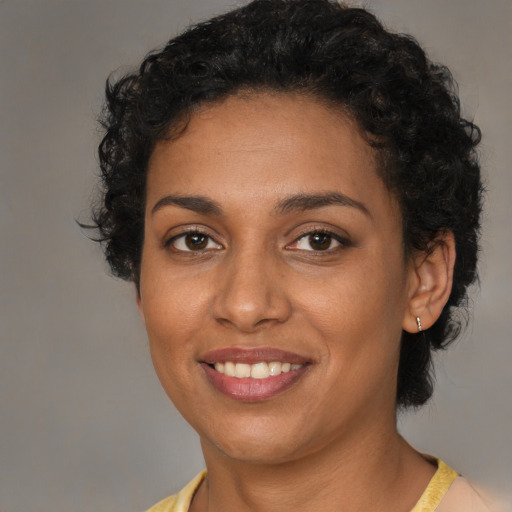 Joyful black young-adult female with short  brown hair and brown eyes