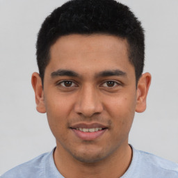 Joyful latino young-adult male with short  black hair and brown eyes