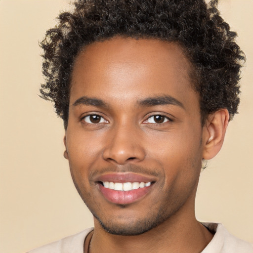 Joyful black young-adult male with short  brown hair and brown eyes