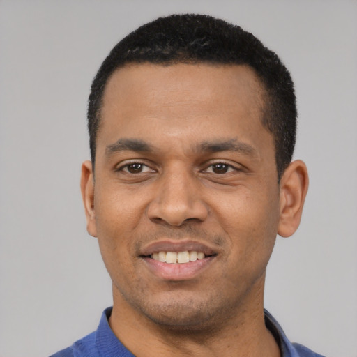 Joyful latino young-adult male with short  black hair and brown eyes