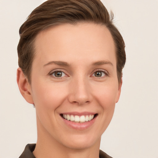 Joyful white young-adult female with short  brown hair and grey eyes