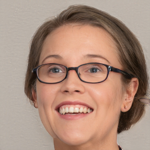 Joyful white adult female with medium  brown hair and blue eyes