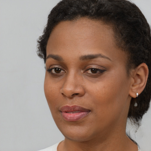 Joyful black young-adult female with short  brown hair and brown eyes