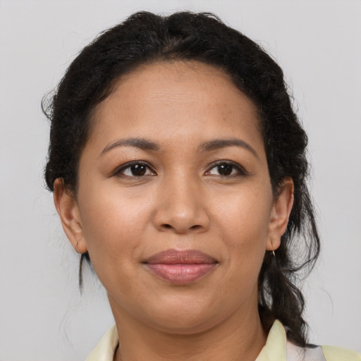 Joyful latino adult female with medium  brown hair and brown eyes