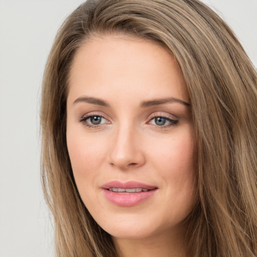 Joyful white young-adult female with long  brown hair and grey eyes