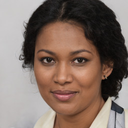 Joyful black young-adult female with long  brown hair and brown eyes