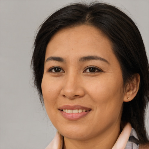 Joyful asian adult female with medium  brown hair and brown eyes