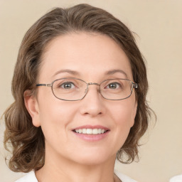 Joyful white adult female with medium  brown hair and green eyes