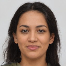 Joyful latino young-adult female with long  brown hair and brown eyes