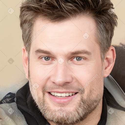 Joyful white adult male with short  brown hair and grey eyes