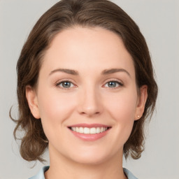 Joyful white young-adult female with medium  brown hair and green eyes