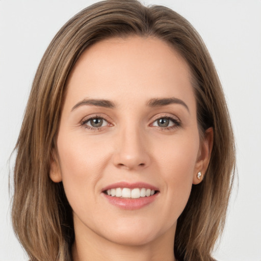 Joyful white young-adult female with long  brown hair and grey eyes