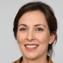 Joyful white adult female with medium  brown hair and brown eyes