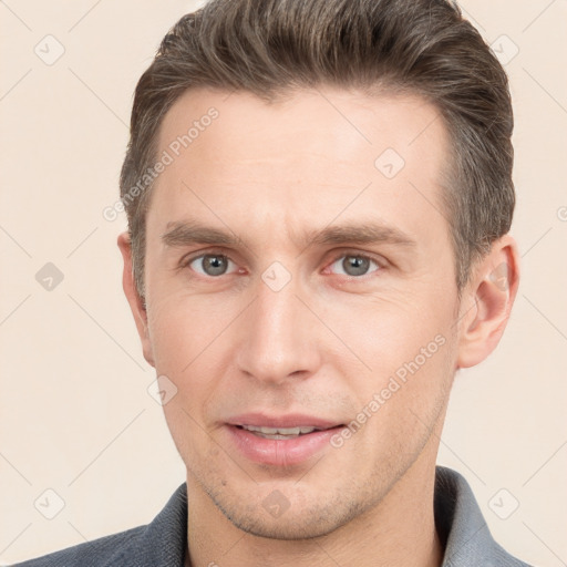 Joyful white young-adult male with short  brown hair and grey eyes