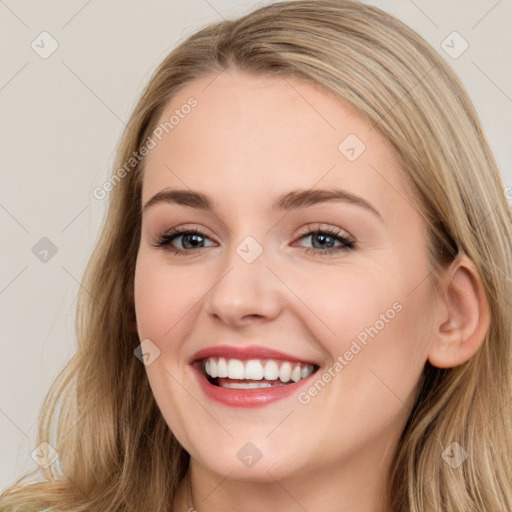 Joyful white young-adult female with long  brown hair and blue eyes