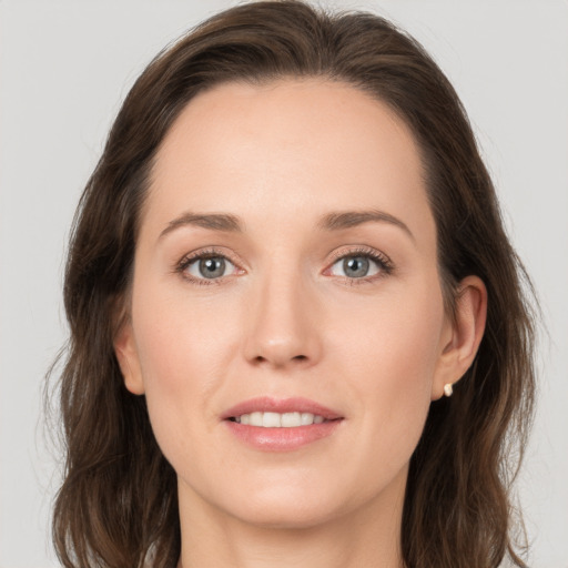 Joyful white young-adult female with medium  brown hair and grey eyes