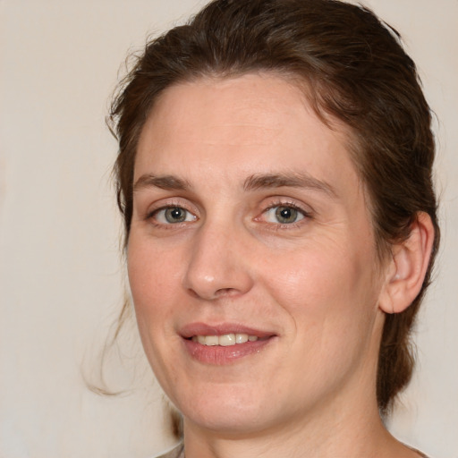 Joyful white adult female with medium  brown hair and green eyes