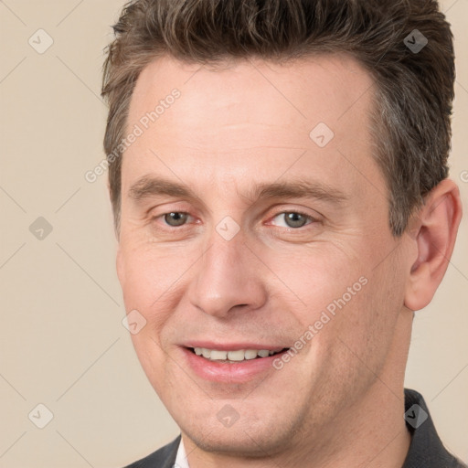 Joyful white adult male with short  brown hair and brown eyes