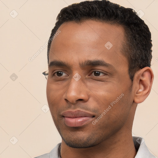 Joyful black young-adult male with short  black hair and brown eyes