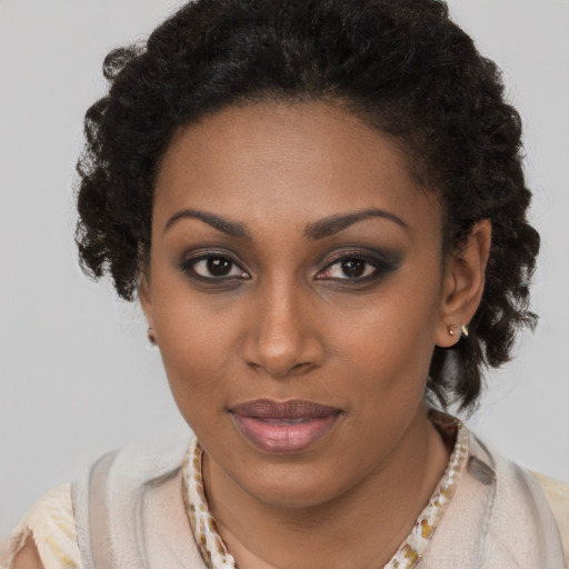 Joyful black young-adult female with long  brown hair and brown eyes