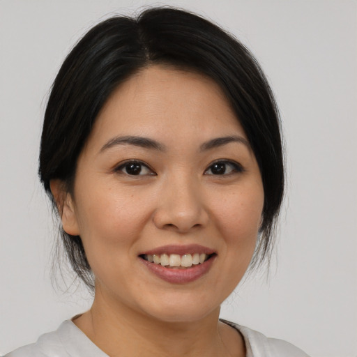 Joyful asian young-adult female with medium  black hair and brown eyes
