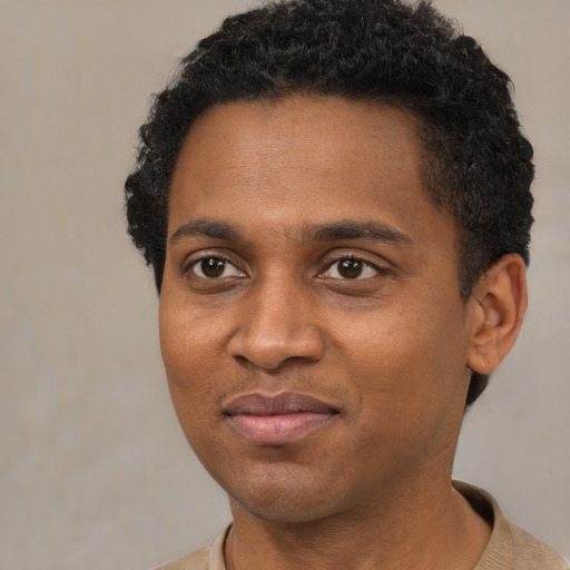 Joyful black young-adult male with short  brown hair and brown eyes