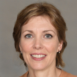 Joyful white adult female with medium  brown hair and grey eyes