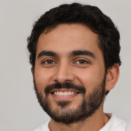 Joyful latino young-adult male with short  black hair and brown eyes