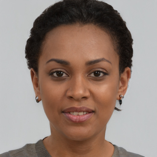 Joyful black young-adult female with short  brown hair and brown eyes