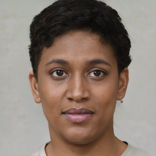 Joyful black young-adult female with short  black hair and brown eyes