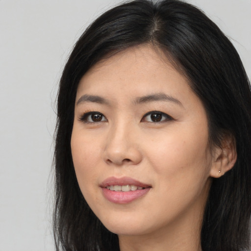 Joyful asian young-adult female with long  brown hair and brown eyes