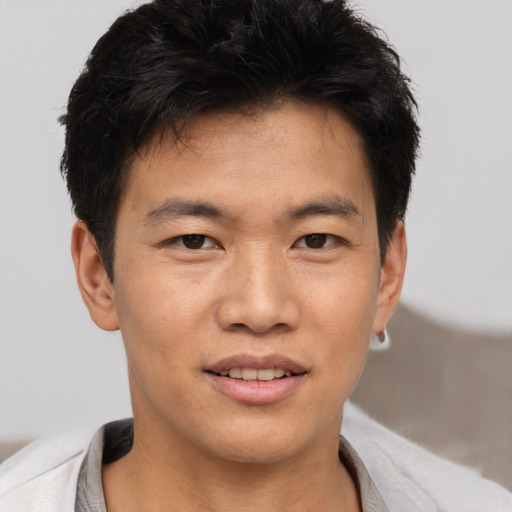 Joyful asian young-adult male with short  brown hair and brown eyes