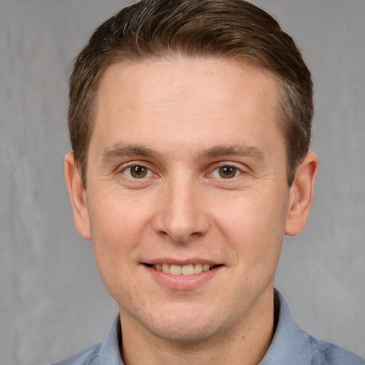 Joyful white adult male with short  brown hair and grey eyes